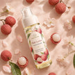 Flat lay of Pink Lychee Perfume Body Mist with lychee fruit, petals and soft blush background