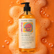 Bottle of Bubble Clinic shampoo rice water keratin shampoo with a colorful label on an orange background with bubbles representing Australian made haircare for damaged and chemically treated har. 