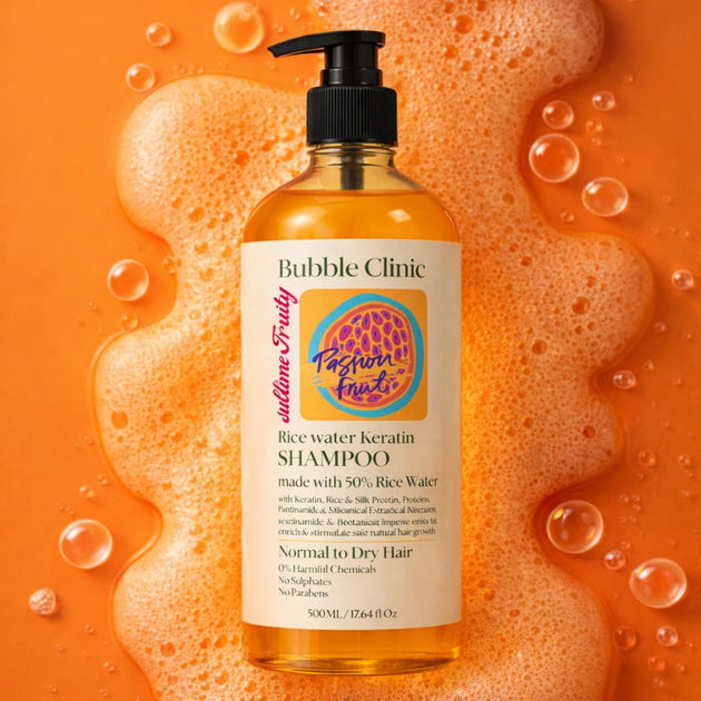 Bottle of Bubble Clinic shampoo rice water keratin shampoo with a colorful label on an orange background with bubbles representing Australian made haircare for damaged and chemically treated har. 