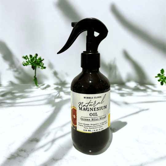 Bottle of natural magnesium oil infused with essential oils with a label on a marble surface with plant shadows.