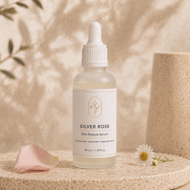 Silver Rose Skin Rescue Serum 50 mL frosted bottle hero image on a beige and stone background