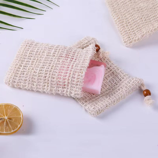image showing organic sisal soap pouches with i soap end on white background with botanicals representing clean organic cleansing routine