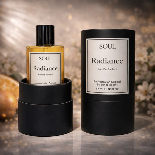 soul radiance australian original aromatherapy perfume inside luxury packaging with flowers and citrus in the background representing essential oils in the fragrance.