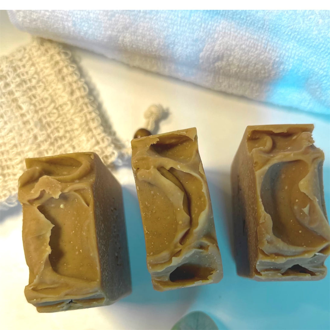 close up top of sulphur soap for acne and rosacea against white bacground with sisal soap saver and towel representing natural ance care and blemish control