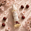 Bubble Clinic Sweet Cherry Body Mist flat lay with cherries and cherry blossom flowers