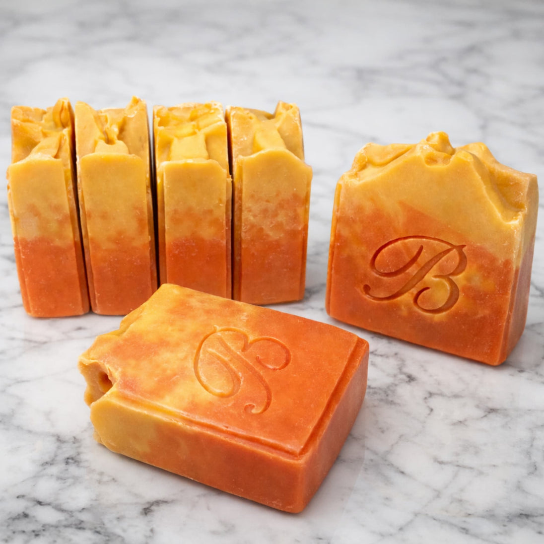 Close up of natural pink and yellow turmeric, alpha arbutin soap with kojic acid and himalayan rhubarb scented in a beautinful natural rose fragrance and packed with organic turmeric, turmeric tallow and oils for brighter and even skin tone. 