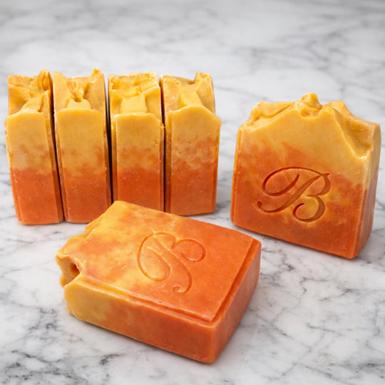 Close up of natural pink and yellow turmeric, alpha arbutin soap with kojic acid and himalayan rhubarb scented in a beautinful natural rose fragrance and packed with organic turmeric, turmeric tallow and oils for brighter and even skin tone. 