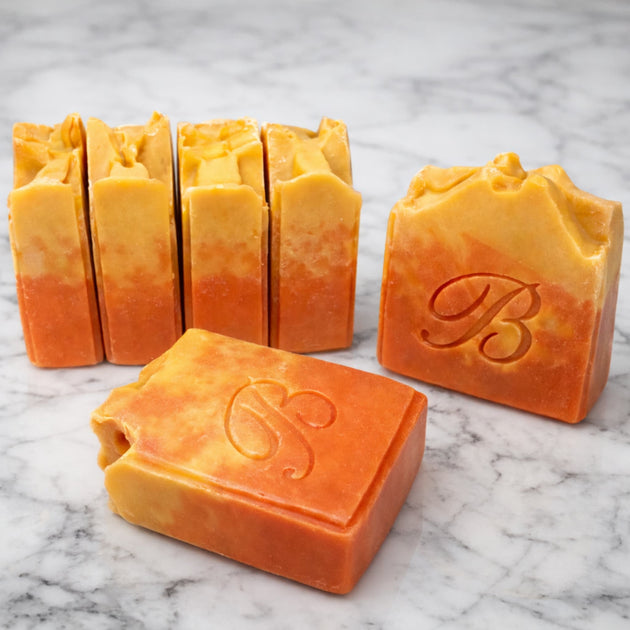 Close up of natural pink and yellow turmeric, alpha arbutin soap with kojic acid and himalayan rhubarb scented in a beautinful natural rose fragrance and packed with organic turmeric, turmeric tallow and oils for brighter and even skin tone. 