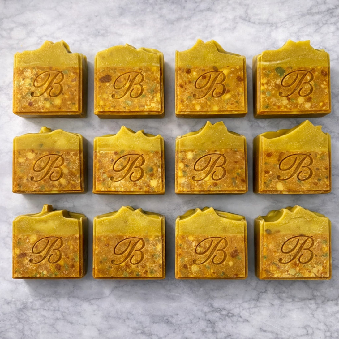 Close up of turmeric alpha arbutin soap with kojic acid, turmeric tallow and oil and scented with essential oil on a light marble surface representing best brightening organic soap Australian made.