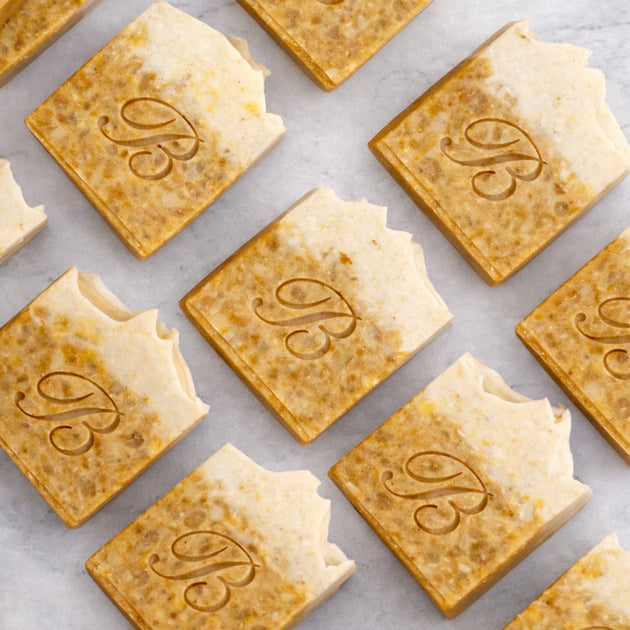 Close up of turmeric alpha arbutin soap with kojic acid, turmeric tallow and oil and scented with peppermint essential oil on a light marble surface representing best brightening organic soap Australian made.