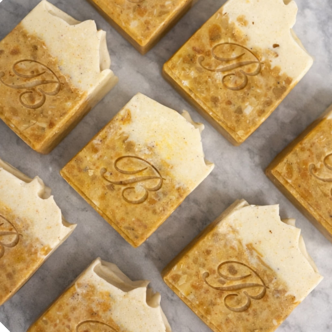 Close up of turmeric alpha arbutin soap with kojic acid, turmeric tallow and oil and scented with peppermint essential oil on a light marble surface representing best brightening organic soap Australian made.