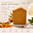 A bar of Bubble Clinic Turmeric & Kojic Acid Soap is displayed on a stone pedestal, surrounded by ingredients like turmeric root, turmeric powder, and white powder, with text highlighting its benefits.