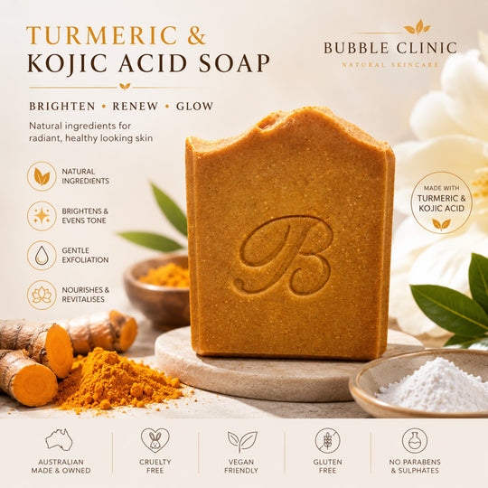 A bar of Bubble Clinic Turmeric & Kojic Acid Soap is displayed on a stone pedestal, surrounded by ingredients like turmeric root, turmeric powder, and white powder, with text highlighting its benefits.