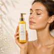 Woman holding Bubble Clinic Brightening Foaming Cleanser beside her face
