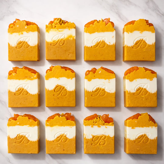 Kojic-niacinamide-turmeric ultra brightening soaps with essential oils - ultra brightening natural turmeric kojic bars stamped with B on a white marble surface representing best natural brightening soap bars.