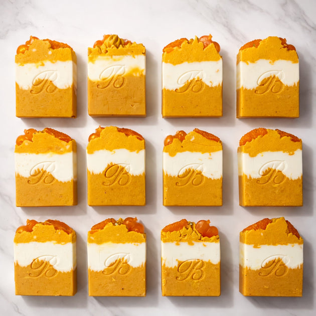 Kojic-niacinamide-turmeric ultra brightening soaps with essential oils - ultra brightening natural turmeric kojic bars stamped with B on a white marble surface representing best natural brightening soap bars.