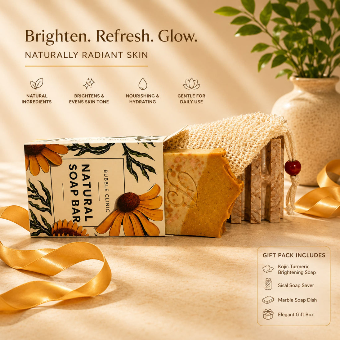 A boxed natural turmeric soap bar set displayed on a warm beige surface with decorative ribbons and a vase in the background. The set includes a floral soap bar in a clear container wrapped with burlap, a matching branded box, and a gift information panel.