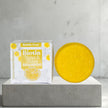 close up of shampoo bar and package box  This solid shampoo gently cleanses with coconut-derived surfactants while taming frizz, enhancing smoothness, and supporting scalp health.