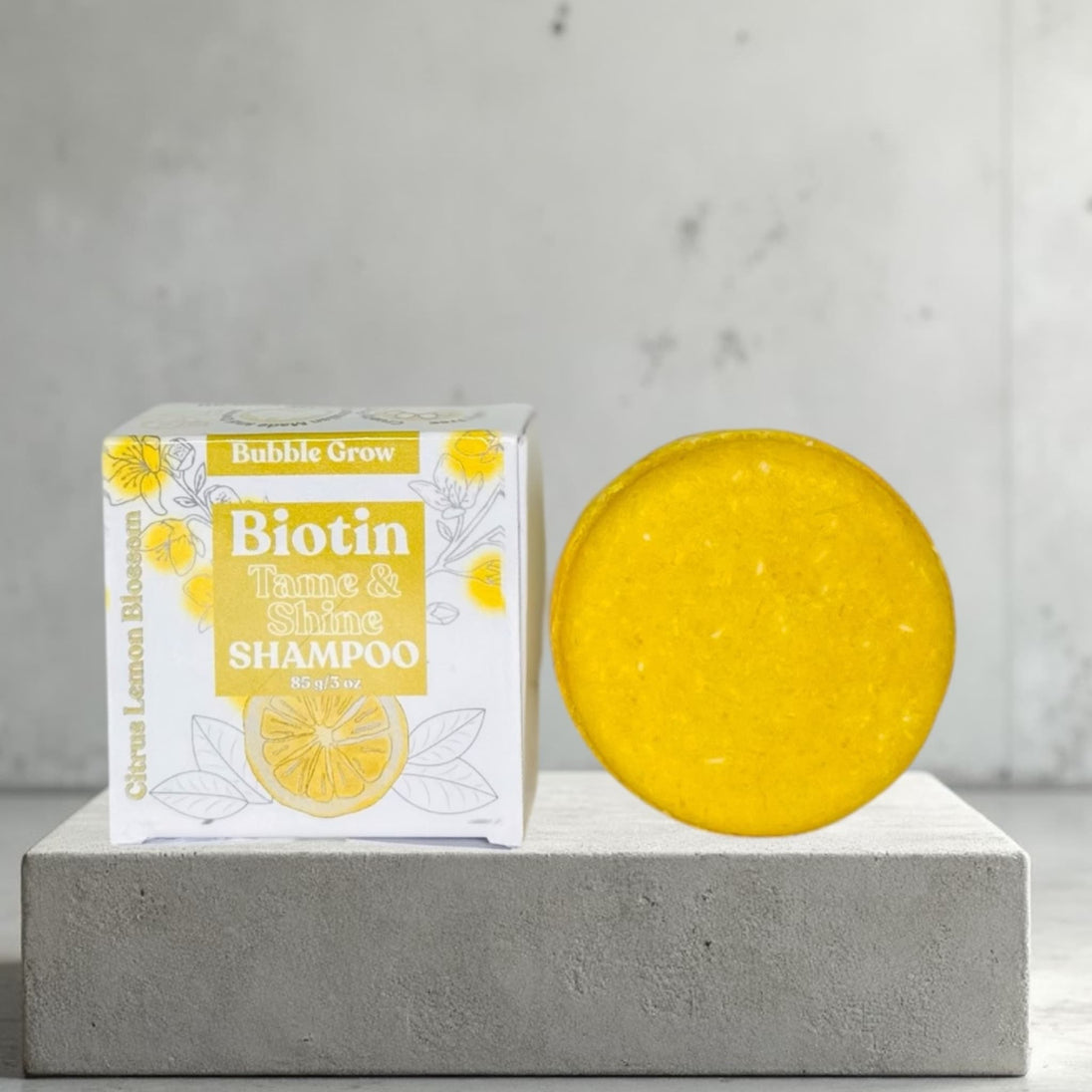 close up of shampoo bar and package box  This solid shampoo gently cleanses with coconut-derived surfactants while taming frizz, enhancing smoothness, and supporting scalp health.