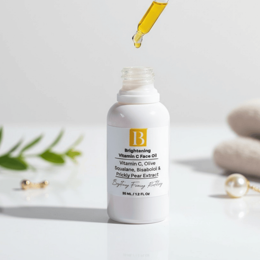 white ceramic bottle with dropper over it revealing clear yellow hue of vitamin c oil with prickly pear on a white background with botanicals and towels representing clean natural australian skincare