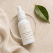 Flat lay of Bubble Clinic Vitamin C Radiance Serum with linen and citrus styling