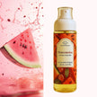 Bottle of Watermelon perfume body mist with a watermelon slice and juice splashes on a pink background representing best Australian body perfume fragrance mists.